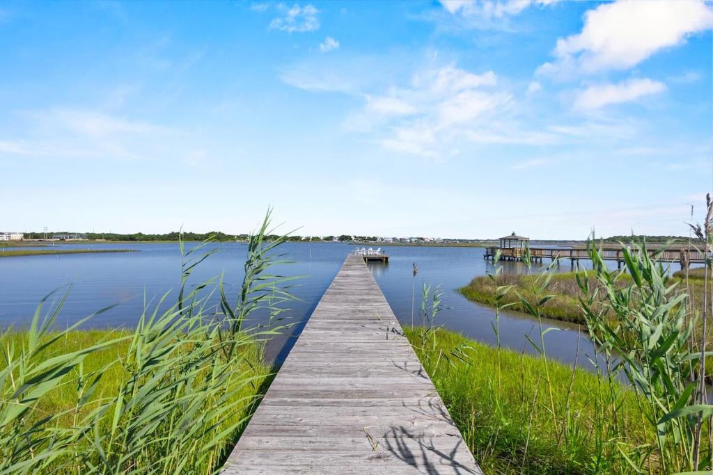 a wooden dock in the middle of a body of water at Luxury Waterfront & Oceanfront Beach Paradise in North Topsail Beach