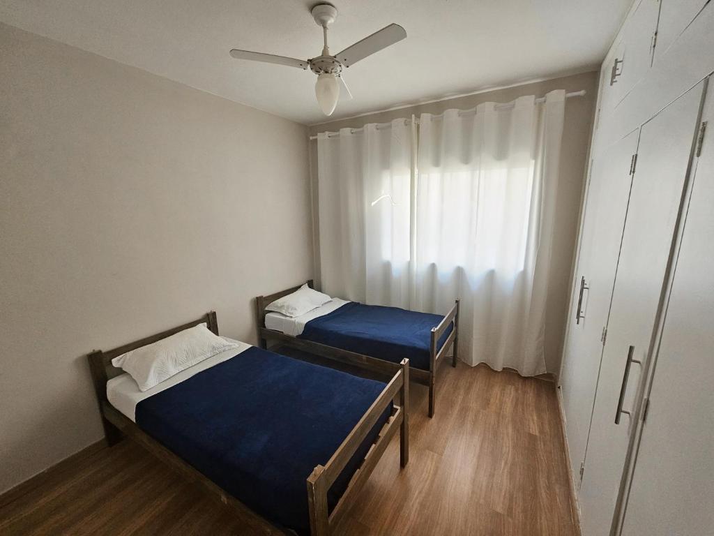 a room with two beds and a ceiling fan at Hotel Deck Taquaral in Campinas