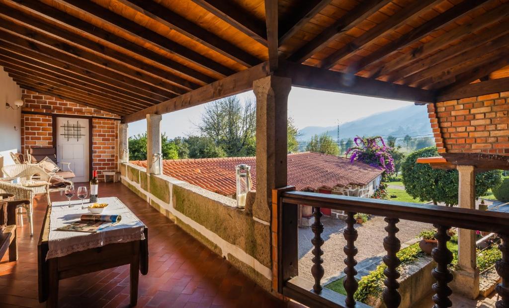 uma vista a partir de uma varanda de uma casa com uma mesa em 1720 Quinta da Cancela - Winery & Farmhouse em Guimarães