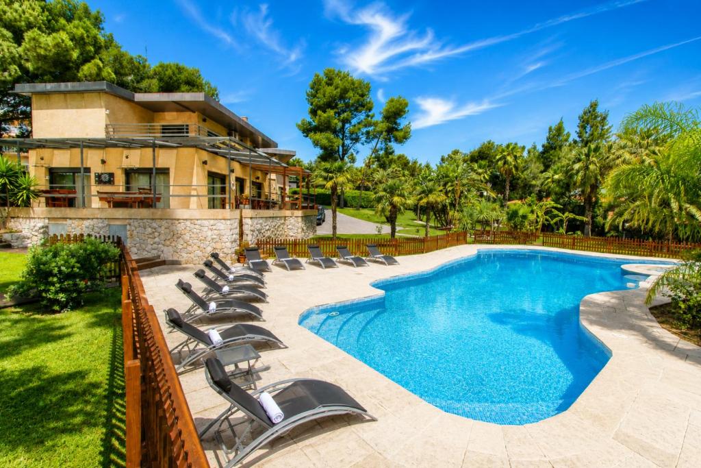 a swimming pool with chairs and a house at New Play Lake Villa in Salou