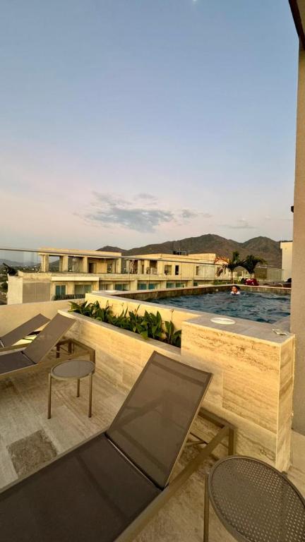 a balcony with a table and chairs and a pool at Apartaestudio tipo loft cerca al mar in Santa Marta
