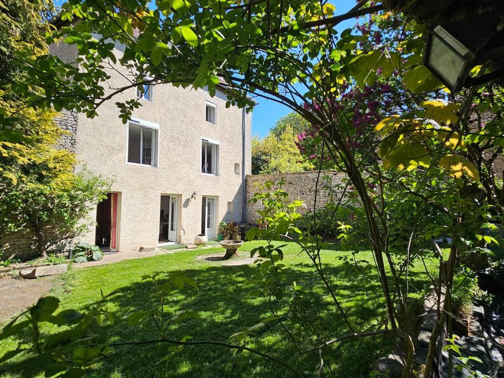 a large stone building with a garden in front of it at L'aparté Roussat in Langres