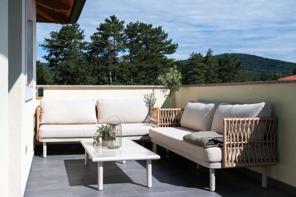 two couches and a table on a patio at I&R Apartma in Hrpelje