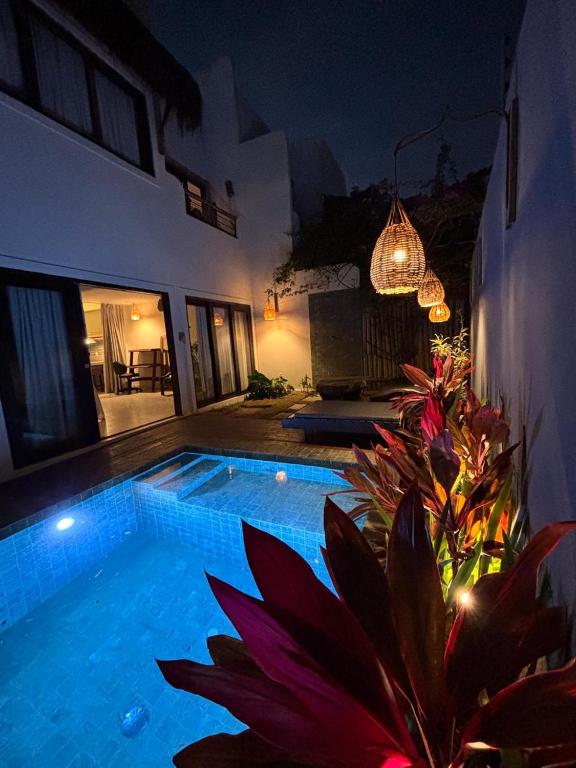 a swimming pool in front of a house at night at Zenhousepipa in Pipa