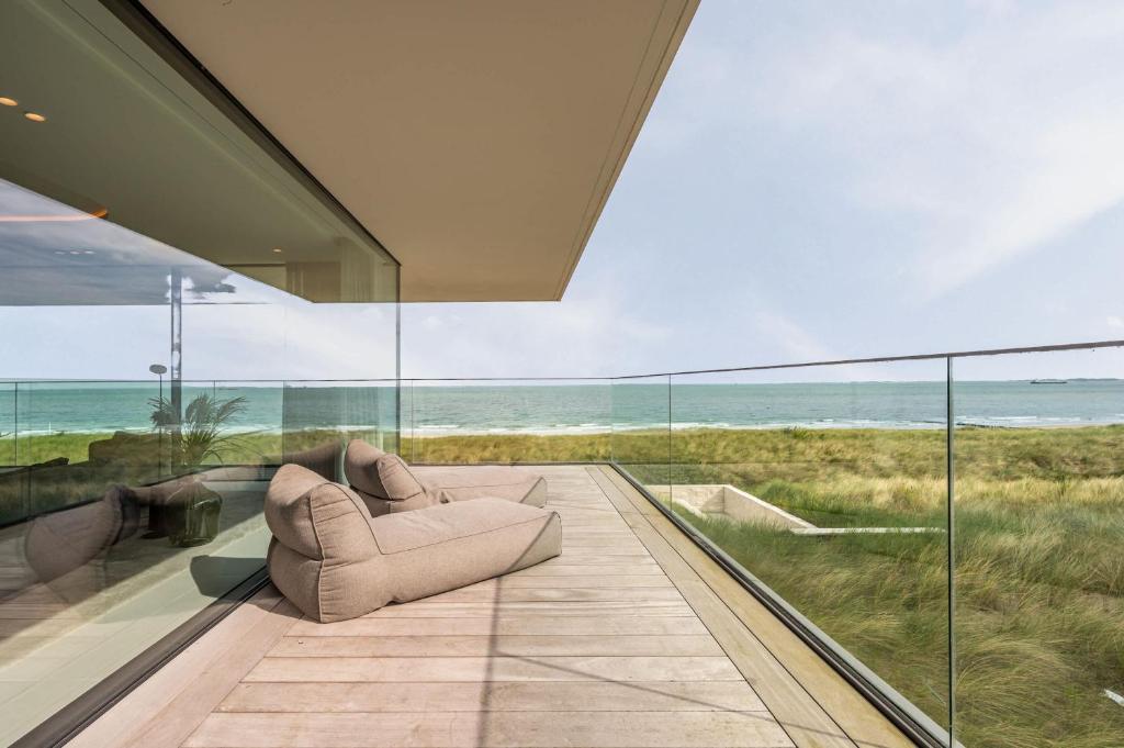 a living room with a couch and a view of the ocean at Residence DeBlanke Top - 1D - Cadzand in Cadzand-Bad