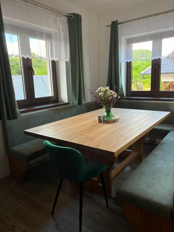 a dining room table with a vase of flowers on it at Apartmán Madlen in Dolní Bobrová