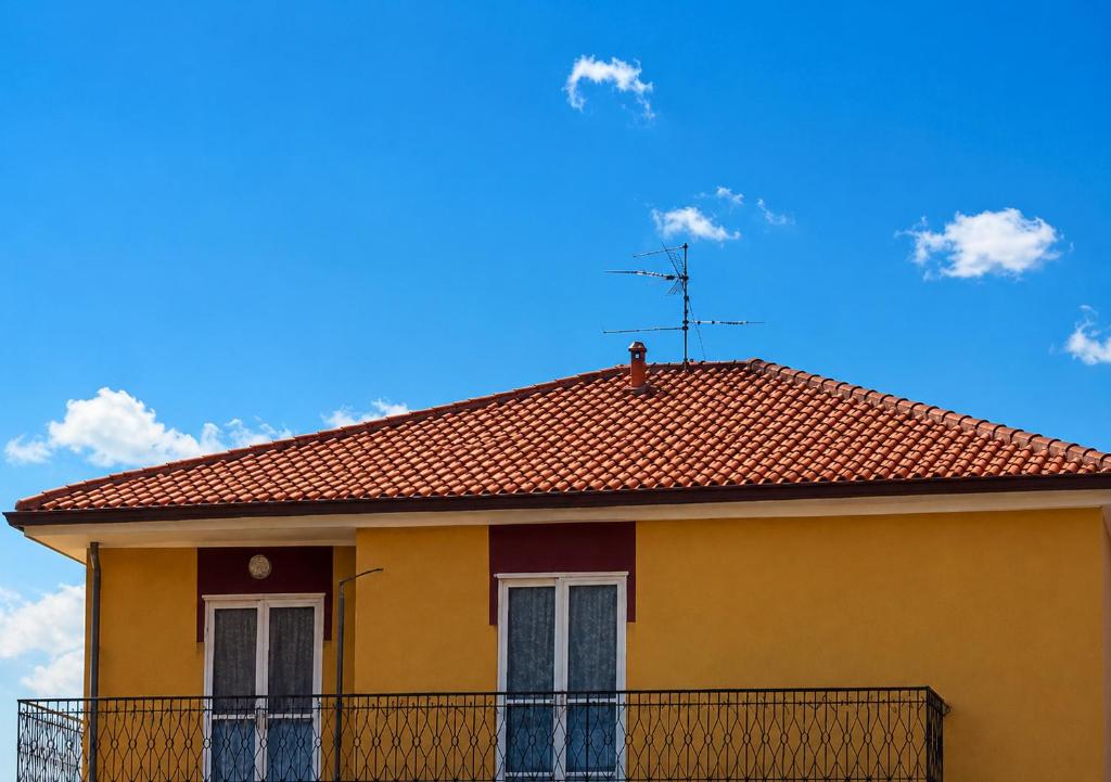 a yellow house with a red roof at Timo e Lavanda in Albenga