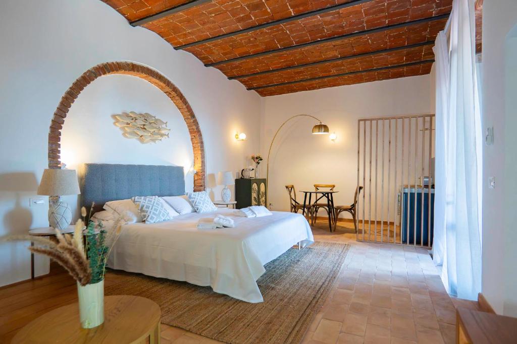 a bedroom with a large bed and a table at Agriturismo Pimpinnacolo in Porto Ercole