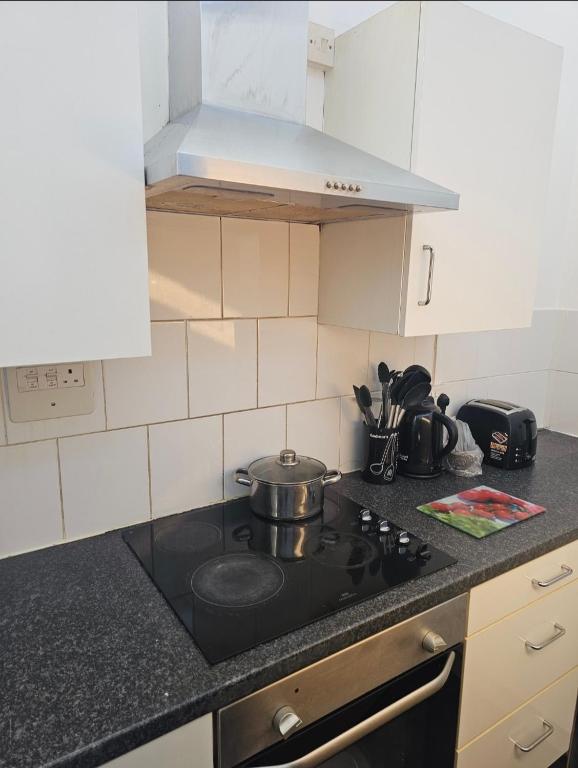 a kitchen with a stove with a pot on it at Roclems Homes in Grays Thurrock