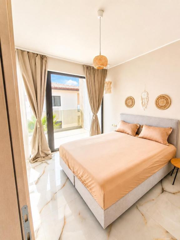 a bedroom with a large bed and a large window at Amore Fanari in Fanari