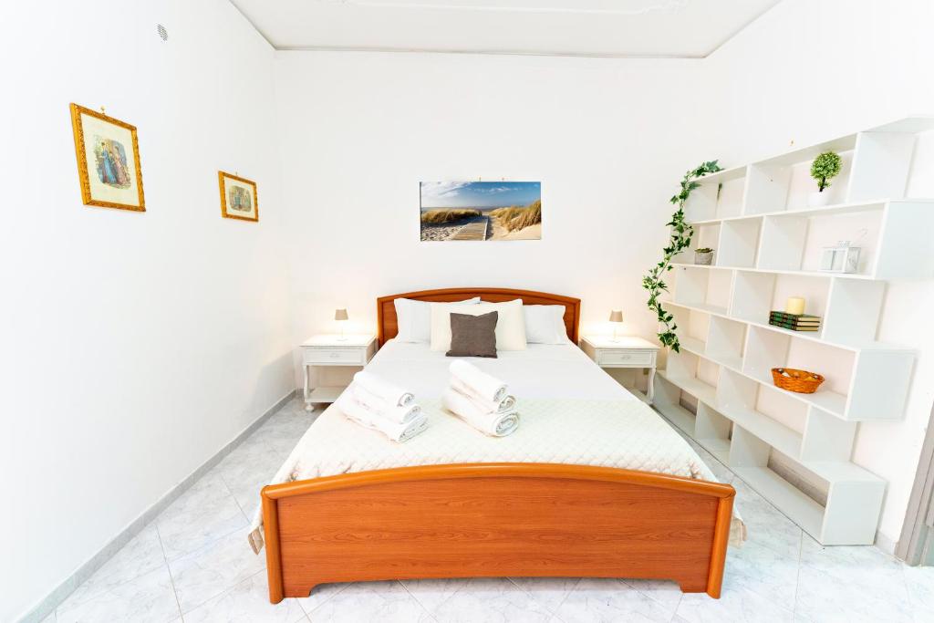 a bedroom with a bed with white shelves at Casa Antonella in Trabia