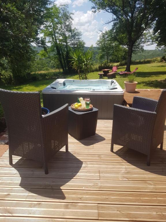 a patio with two chairs and a hot tub at Maison d'hôtes en grès rouge in Lanteuil