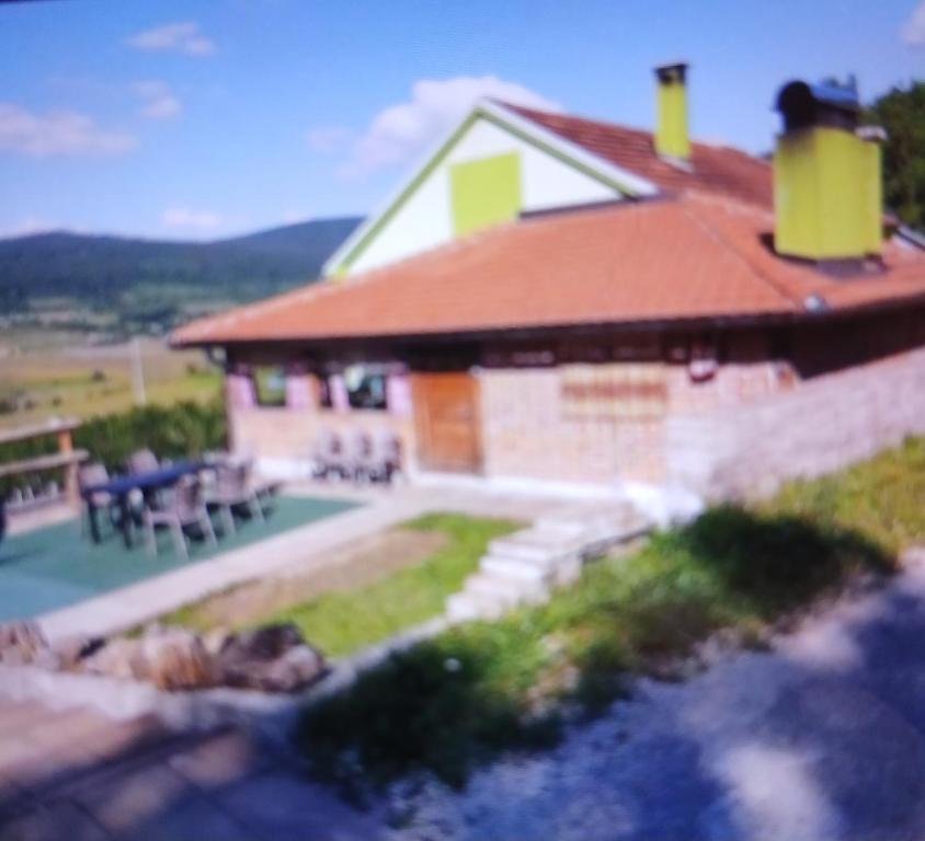 a large house with a patio and a yard at Regina de la Montania in Pajići