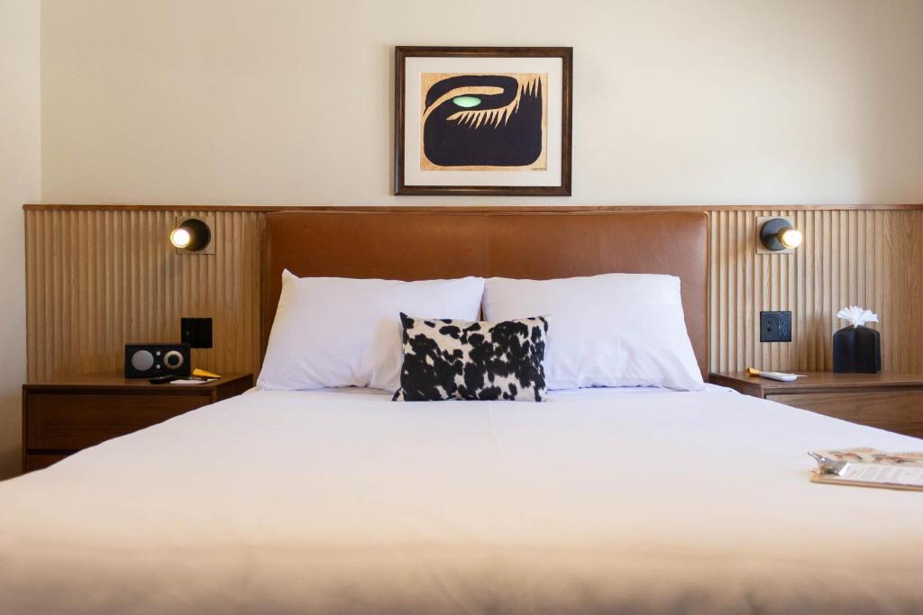 a bedroom with a large bed with white sheets at The Stranger Lodge - Pet Friendly in Sisters