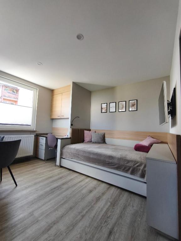 a bedroom with a bed and a desk and a window at Am Flutgraben in Adorf