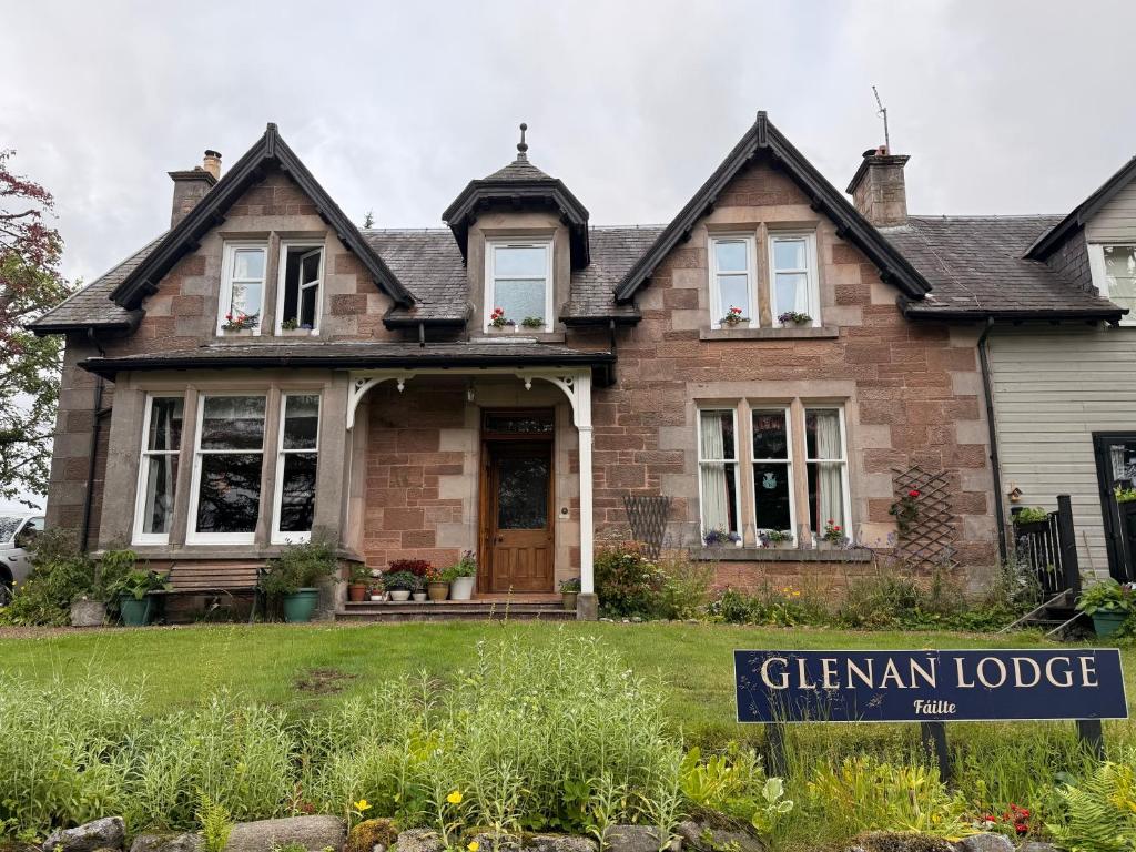 a house with a sign in front of it at Glenan Lodge Self Catering in Tomatin
