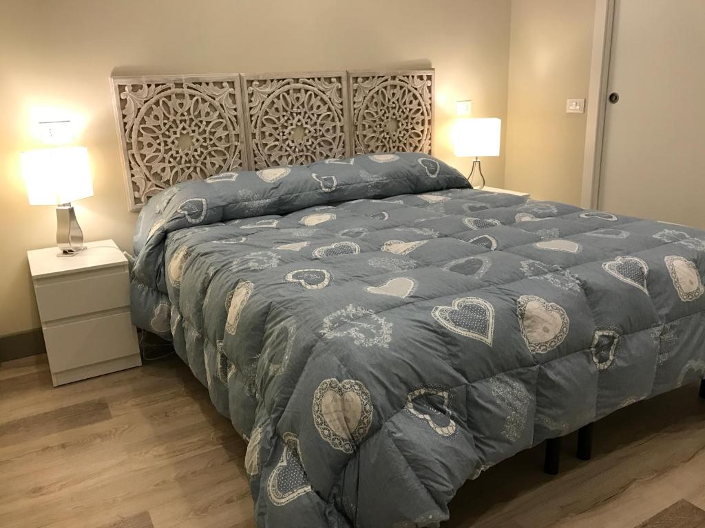 a bedroom with a bed with a blue comforter and two lamps at Dimora Spina in centro in Campobasso