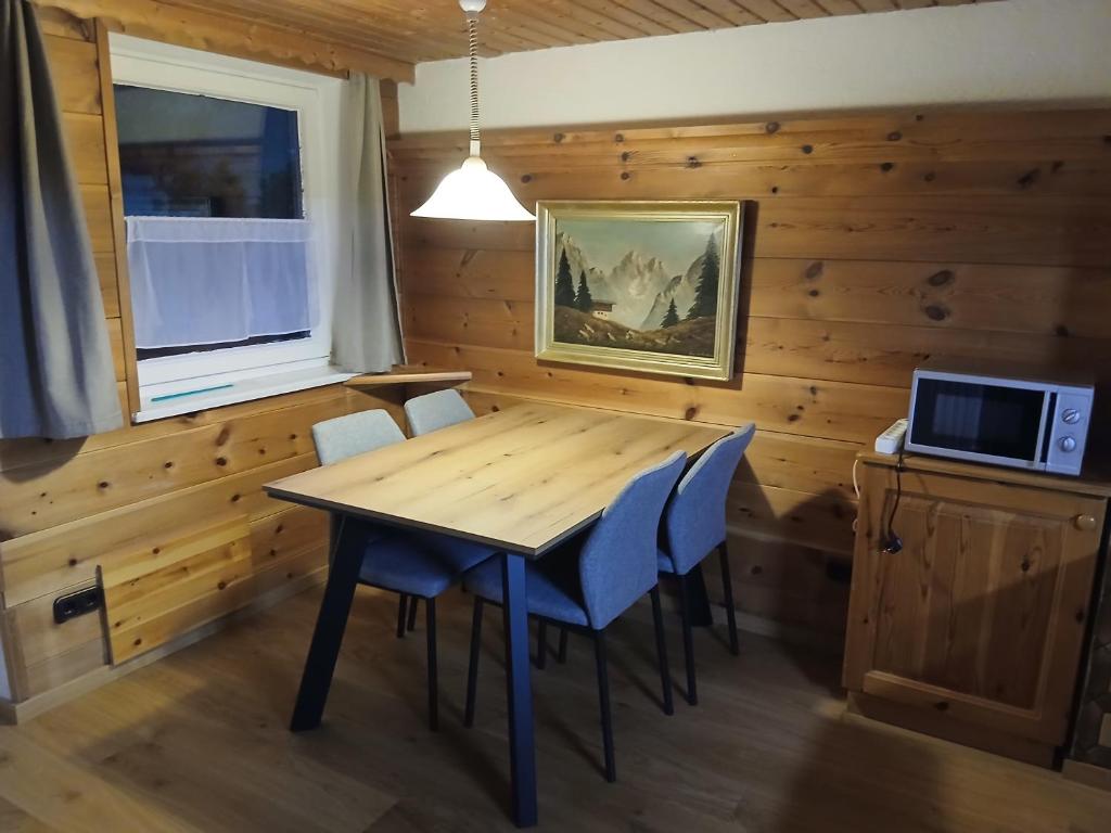 a dining room with a wooden table and chairs at Haus am Wörtherberg in Rauris