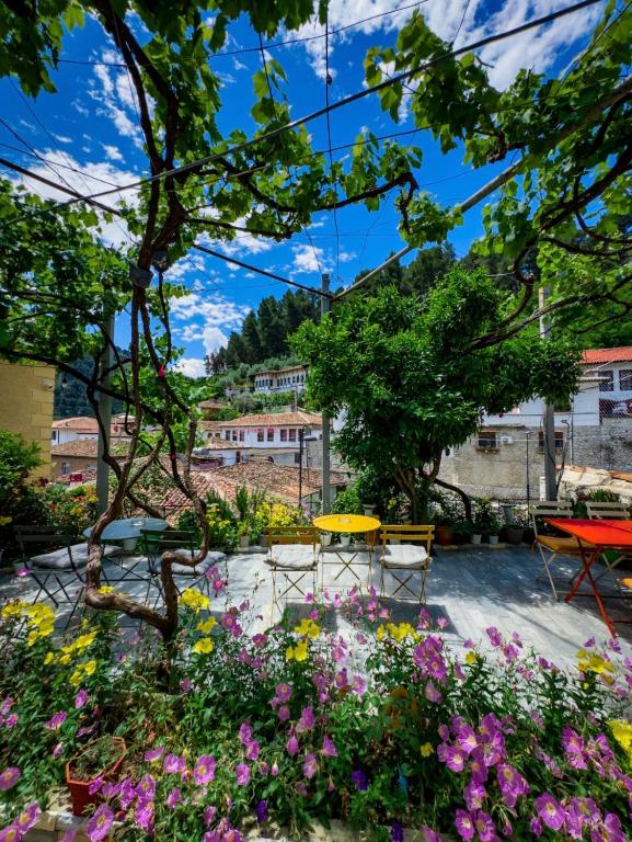 a garden with flowers and a table and chairs at Nika's Guest House in Berat