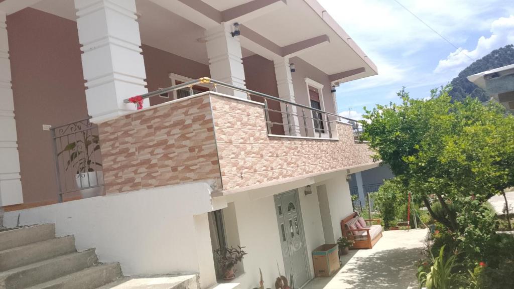 a white house with a balcony and stairs at ArsonGuest in Berat
