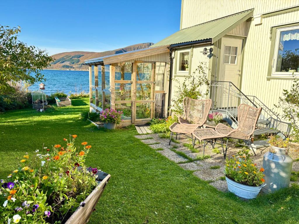a garden with chairs and flowers in front of a house at Fornes Bed & Breakfast in Fornes
