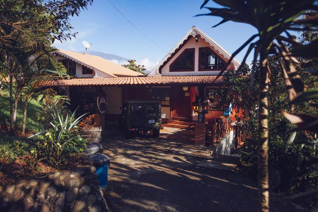 a house with a palm tree in front of it at Spanish by the River - Turrialba in Turrialba