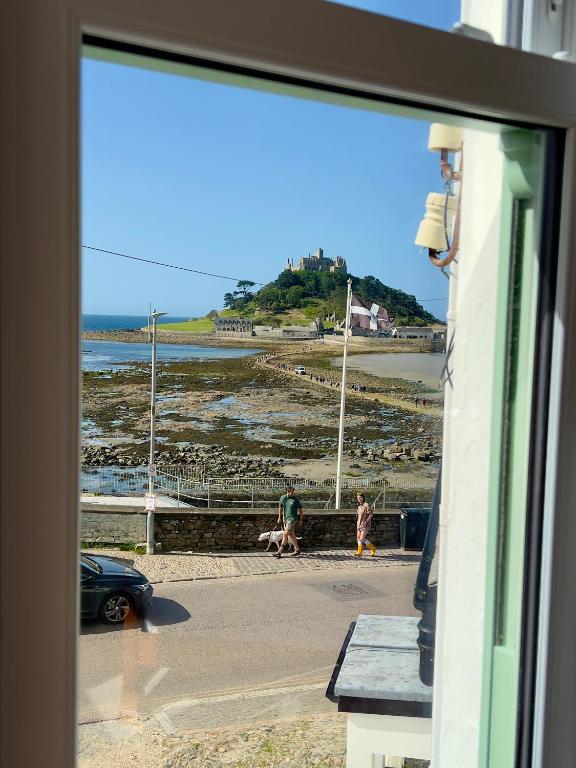a window of a building with a view of the ocean at St Michaels Reach Guest House in Marazion