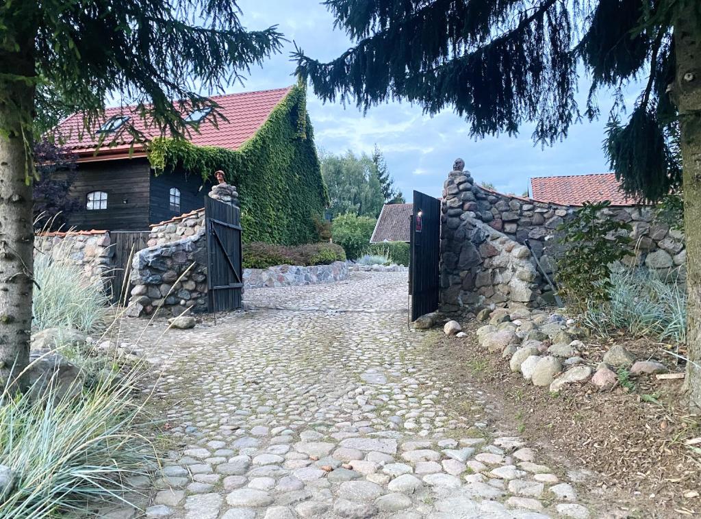 a stone path with a gate and a stone wall at Siedlisko Żywe Kamienie in Naguszewo