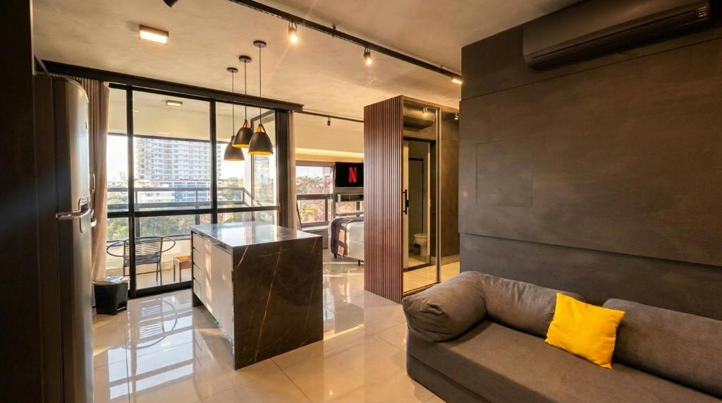 a living room with a couch and a counter at Vista Ampla e Estilo Industrial nesse Lindo Loft in Campo Grande
