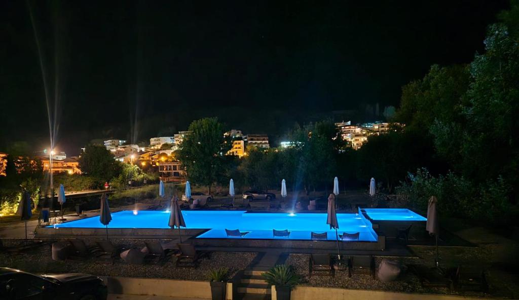 a swimming pool at night with a city in the background at Casa Lu in Ulcinj
