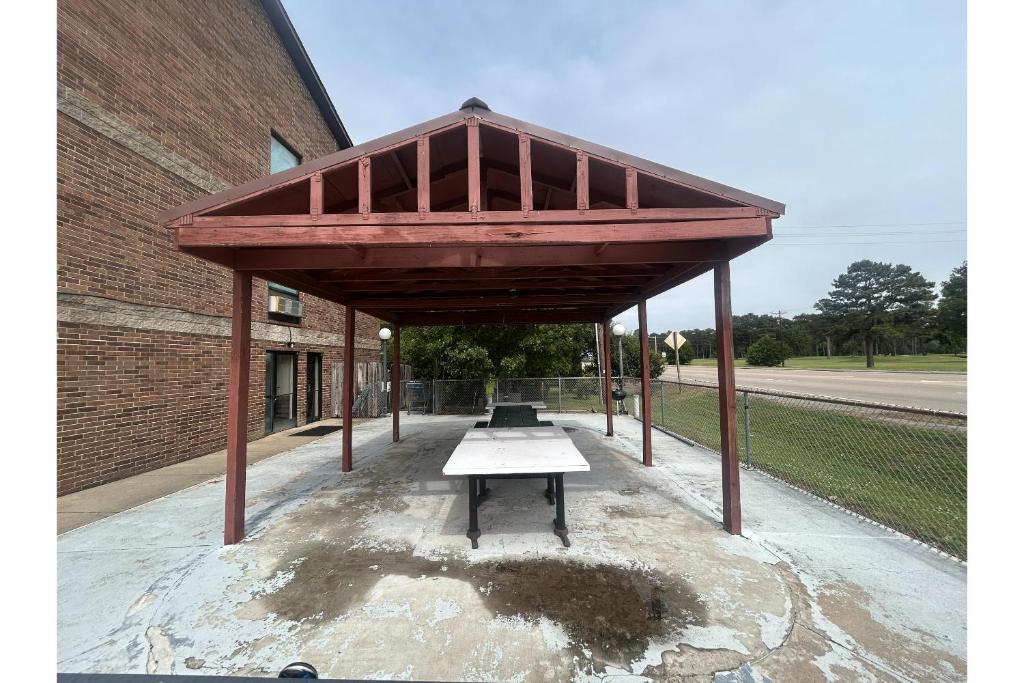 a pavilion with a bench in front of a building at Rockwood Inn Kennett I 55 Near Blytheville in Kennett