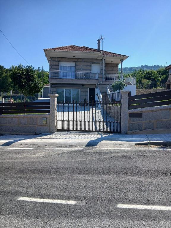 a house with a gate in front of a street at A Lucita-Ribeira Sacra in Rubiacós