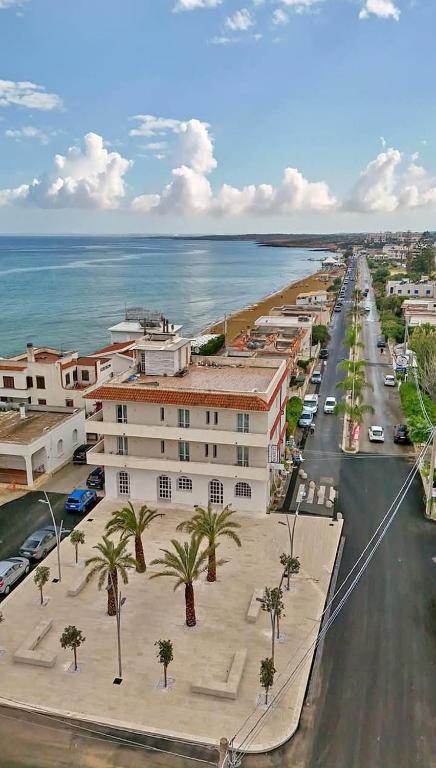 an aerial view of a city with palm trees and the ocean at Hotel Noto Marina Meeting Vista Mare in Noto Marina
