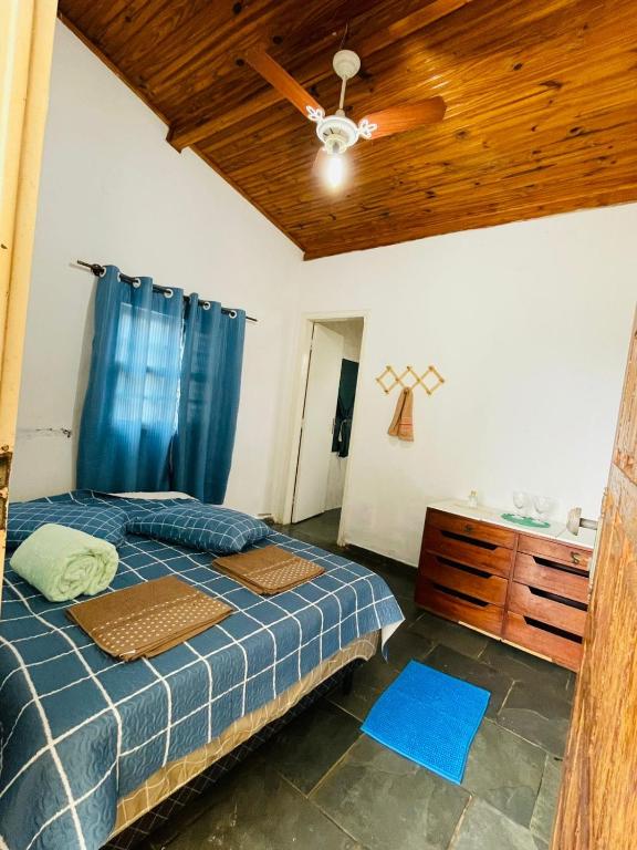 a bedroom with a bed and a ceiling fan at Pousada Canastra Raíz in Delfinópolis