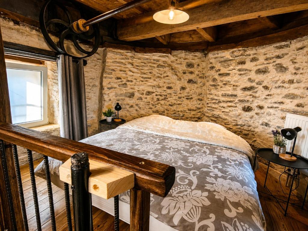 a bedroom with a bed in a brick wall at Le Moulin Neuf, logements atypiques dans le Pays d'Ancenis in Anetz