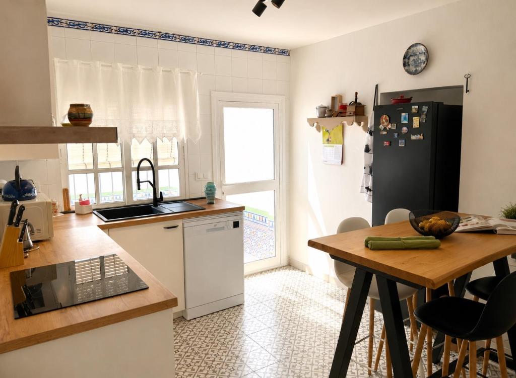 a kitchen with a table and a black refrigerator at Casa Juana in Facinas