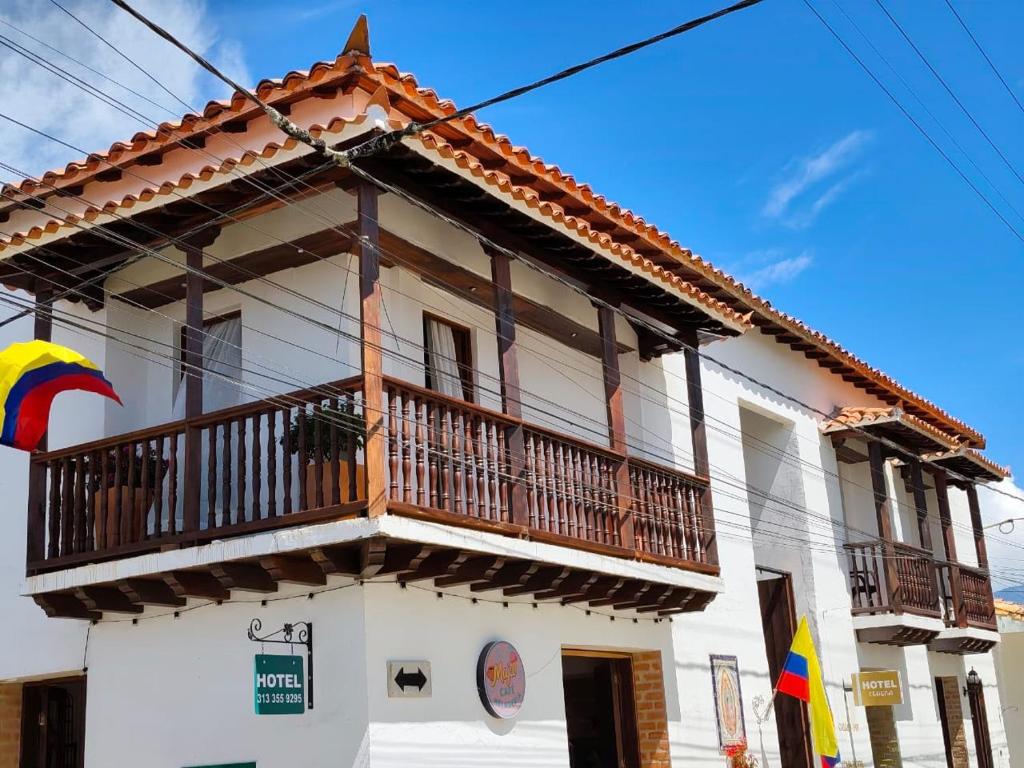 a white building with a balcony on top of it at Casa Hotel Serena in Guadalupe