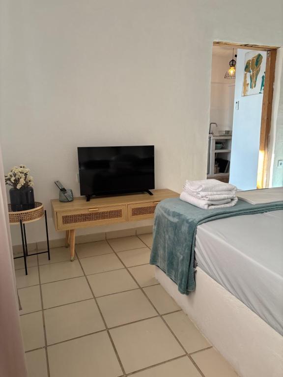 a living room with a tv and a bed at 7Olives Azure Boutique Apartment in Kastraki