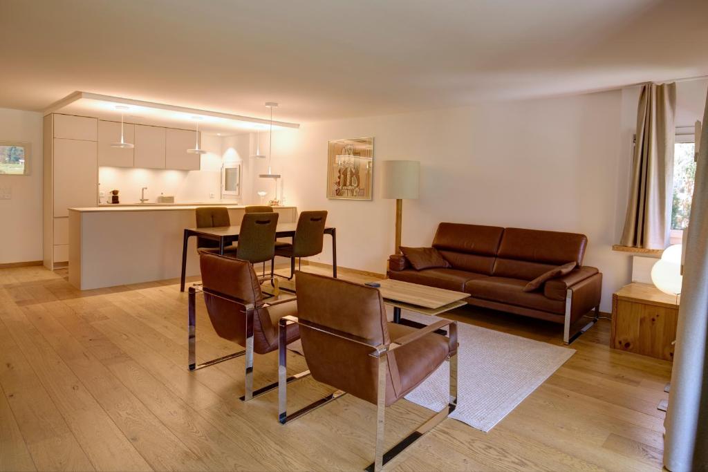 a living room with a couch and a table and chairs at Chesa Munteratsch 2-Zimmerwohnung 101 Typ E in Silvaplana
