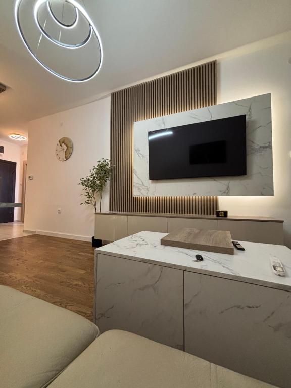 a living room with a tv on the wall at Apartman NOVA in Kragujevac