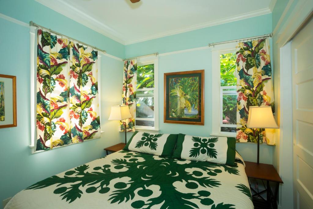 una camera da letto con un letto e due finestre di Iao Valley Inn a Wailuku