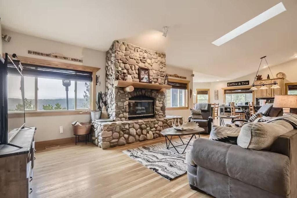 a living room with a large stone fireplace at Mountain Retreat - Deck Views - Sleeps 10 in Black Hawk