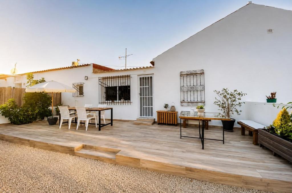a patio with a table and chairs and a white house at Casa Perico Reyes in Cartagena