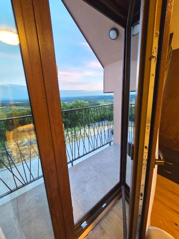 an open glass door to a balcony with a view at Petar in Kamešnica