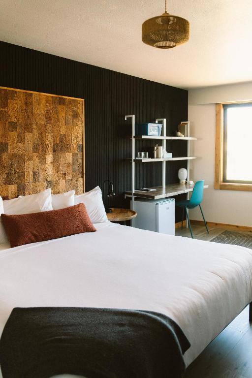 ein Schlafzimmer mit einem großen weißen Bett und einem Schreibtisch in der Unterkunft Adrift Hotel in Long Beach