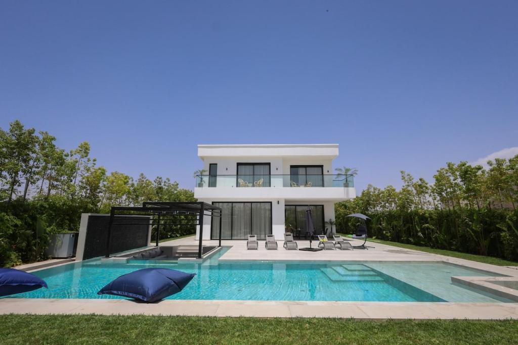 a house with a swimming pool in front of a house at Villa de luxe, petit déjeuner compris Golf in Marrakesh