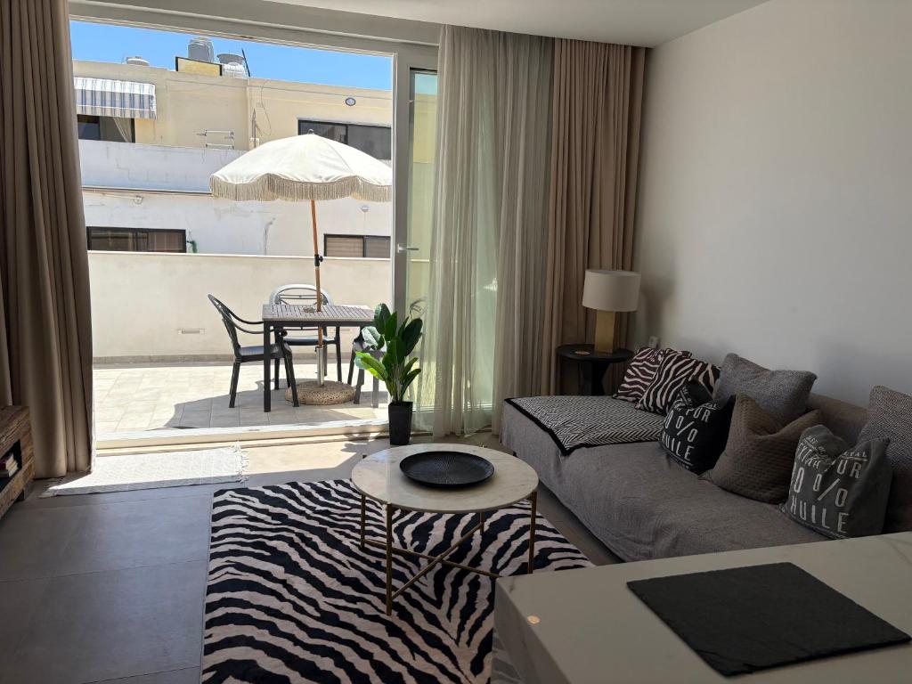 a living room with a couch and a zebra rug at Cute little Penthouse in the Heart of Sliema in Sliema
