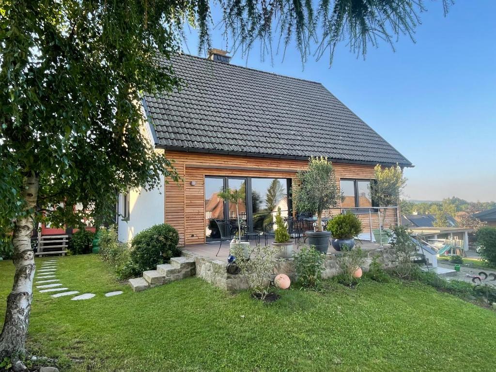 a house with a large window and a yard at Bergflamme - Ihr Ferienhaus im Harz mit Panoramasauna in Braunlage