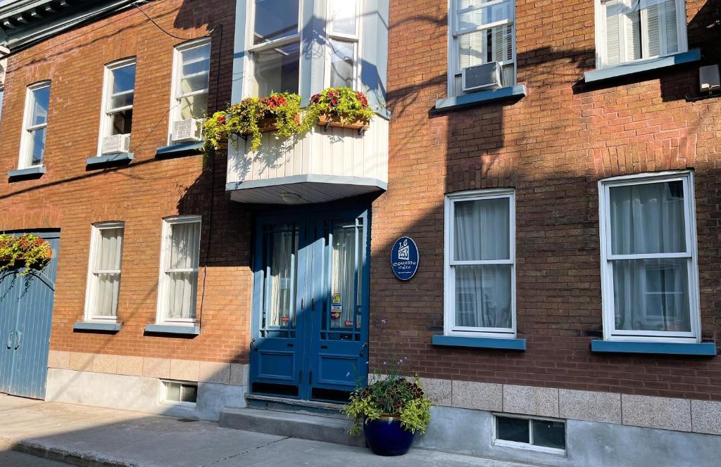 a brick building with a blue door and windows at Le 253 in Quebec City
