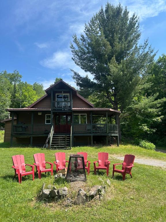 a group of red chairs in front of a house at Chalet de toutes saisons in Shawinigan